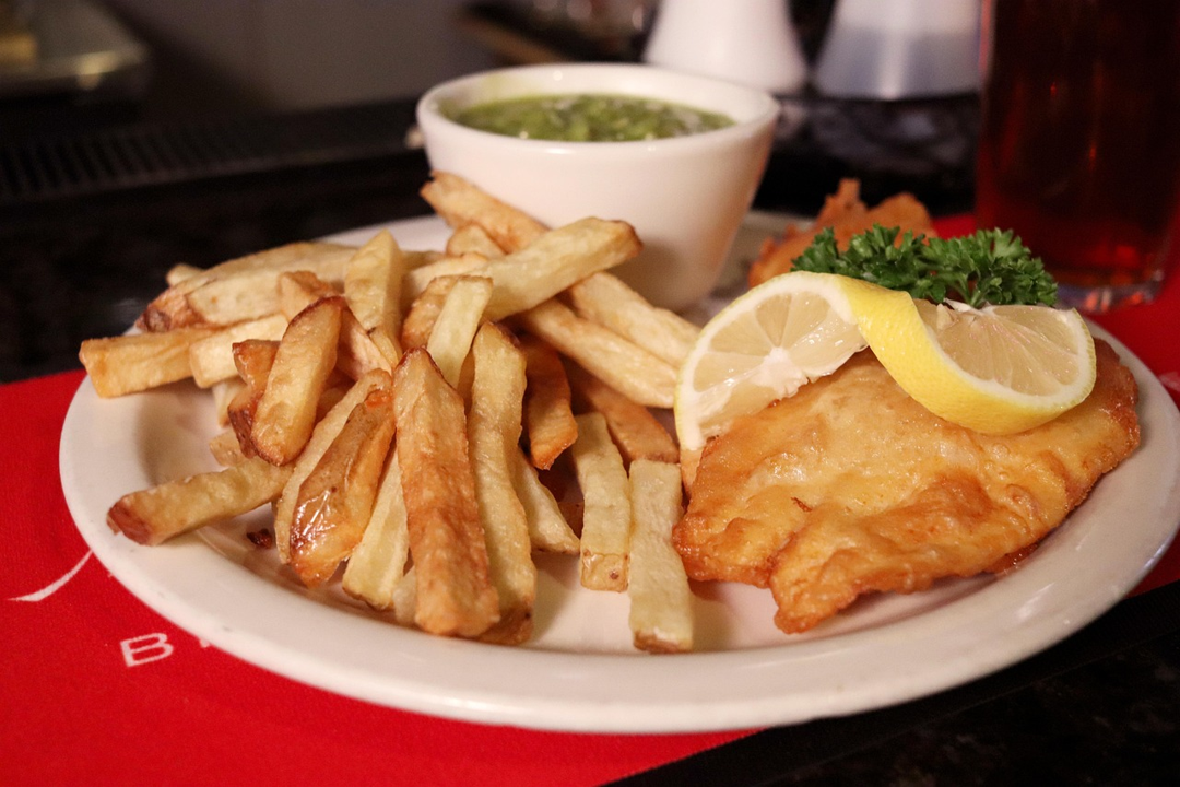 A plate of fish and chips with mushy peas