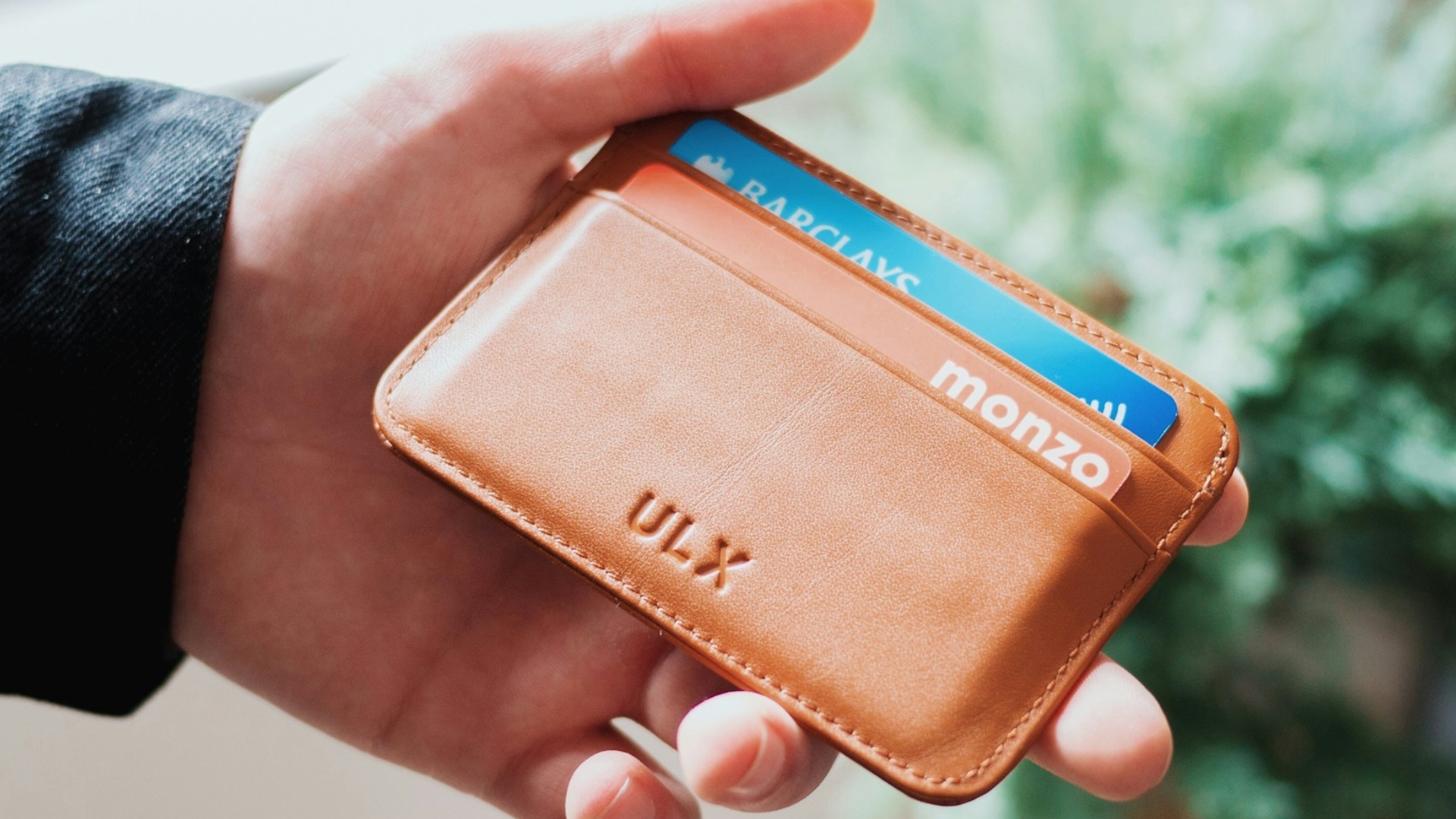 Person holding a wallet containing bank cards