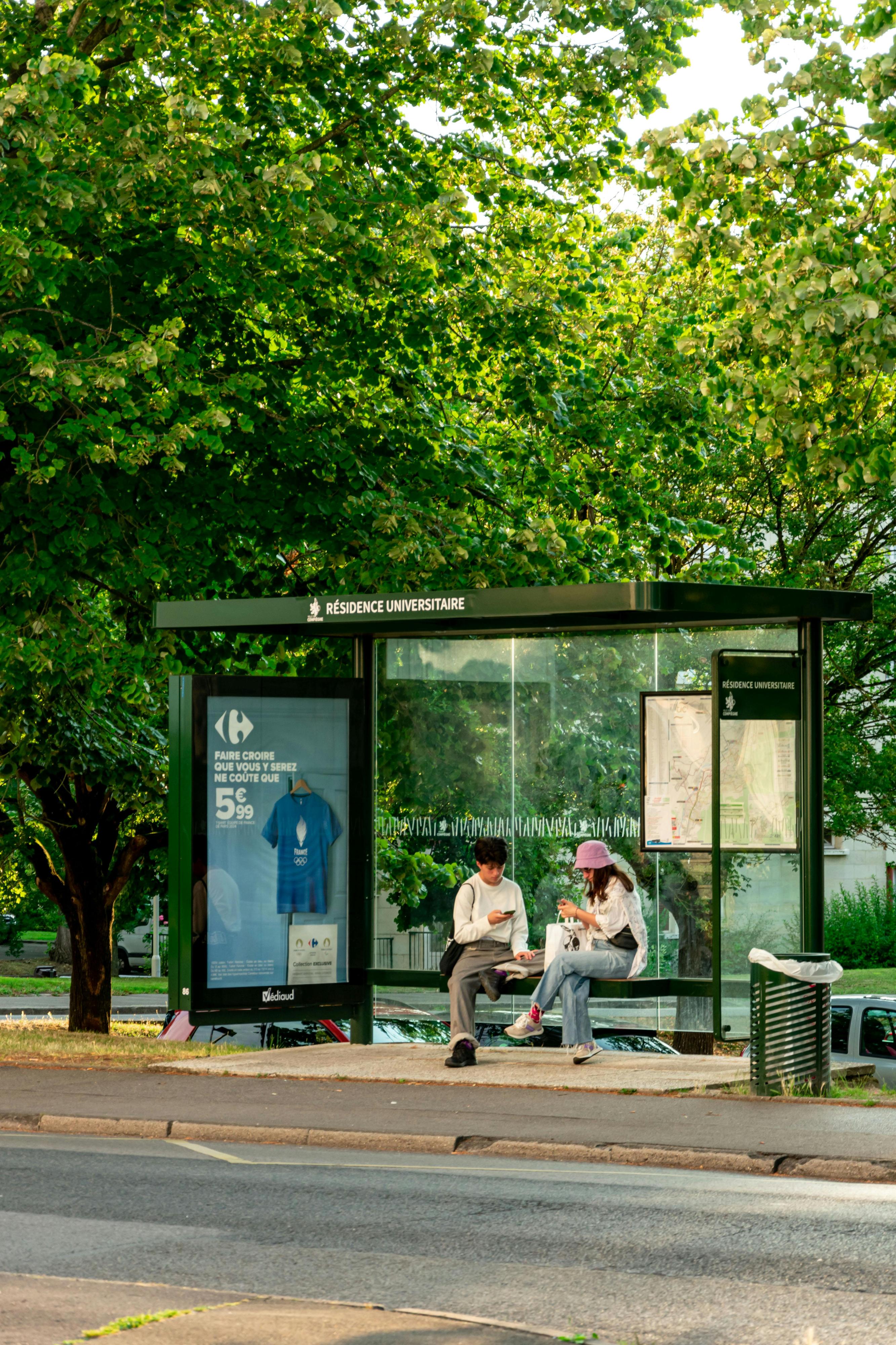 Two students waiting for the bus in front of their student residence.